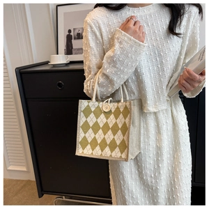 Detailed close-up of small yellow argyle canvas tote bag with button and rope handle