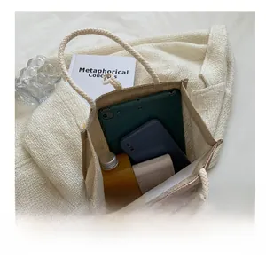 Vue intérieure d'un sac cabas tissé beige montrant le rangement pour tablette et objets