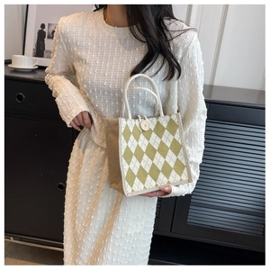 Detail of green and beige quilted canvas tote bag with woven rope handle and wooden button