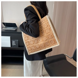 Détail du grand cabas à carreaux tuftés sur un bureau pour un look professionnel
