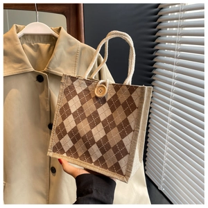 Detail of canvas tote bag with brown diamond pattern, cotton rope handle and wood button