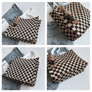 Detail of checkered canvas tote bag featuring a cute brown rabbit plush charm and handles