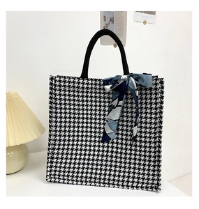 Detail of large houndstooth canvas tote bag with silk scarf and black handles
