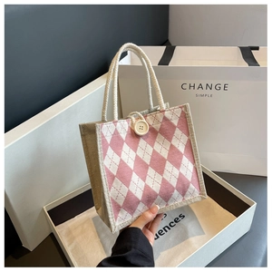 Close-up of pink and white argyle canvas tote bag with button detail and rope handles