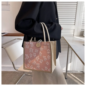 Detailed shot of pink floral linen tote bag with white daisy embroidery and wood button