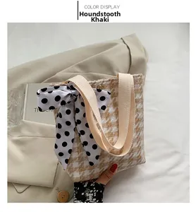 Detail of khaki houndstooth tote bag with a polka dot bow and metallic snap button