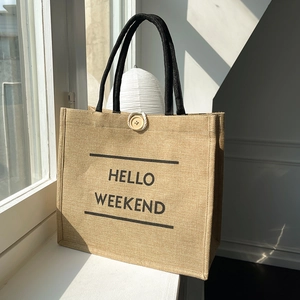 Large jute tote bag with Hello Weekend print and black handles for daily commute