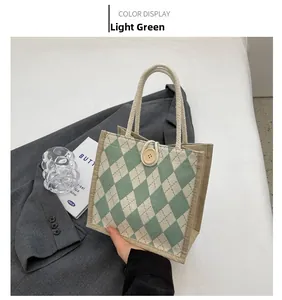 Detail of light green quilted canvas tote with wooden button closure and rope handles