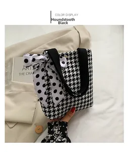 Detail of houndstooth tote bag with polka dot bow accent and black fabric handles