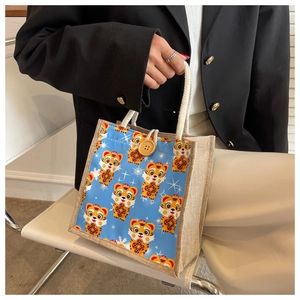 Detail of cartoon tiger print on blue linen tote bag with cotton rope handle and button