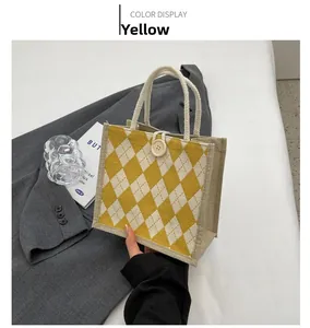 Detail of yellow argyle canvas tote bag with woven rope handle and button closure
