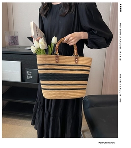 Detail of woven beach tote featuring bamboo handles and contrast stripe texture