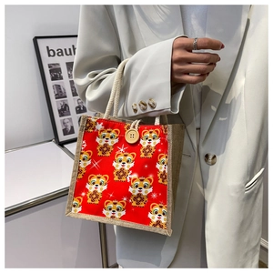 Close-up of red burlap bag with cartoon tiger print, rope handles and wooden button