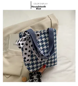 Detail of blue houndstooth canvas handbag with decorative black and white polka dot ribbon