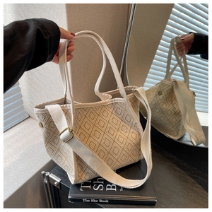 Detailed view of beige canvas tote with geometric jacquard pattern and leather straps