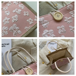 Détail du sac à main tissé rose avec fleurs en tissu, côtés en jute et bouton en bois