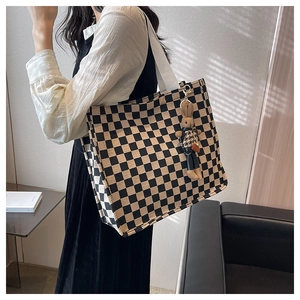 Classic checkered canvas tote bag with rabbit charm shown in a lifestyle indoor setting