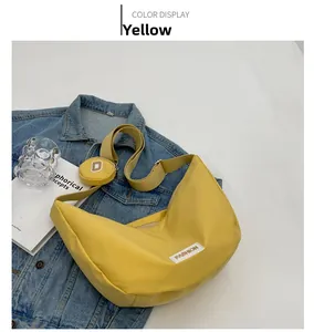 Détail du sac demi-lune en nylon jaune avec mini porte-monnaie sur veste en jean