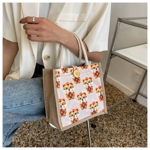 Detail of cute cartoon tiger linen handbag with woven cotton handle and wooden button