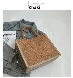 Gros plan du sac cabas kaki avec texture quadrillée à franges et anses tressées marron
