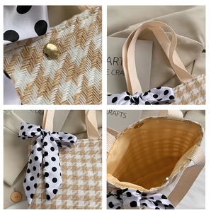 Detail of yellow houndstooth woven tote bag with polka dot bow and magnetic snap closure