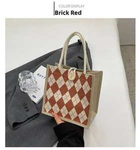 Detail of brick red and beige canvas tote bag with diamond pattern and wooden button