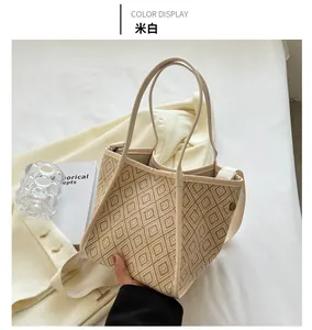 Chic cream woven tote bag styled with a white blazer and books in a modern lifestyle setting
