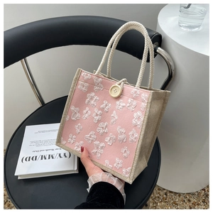 Détail du sac à lunch rose avec fleurs 3D et poignées en toile de jute naturelle