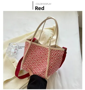 Detail of red and white woven geometric tote bag with adjustable red shoulder strap