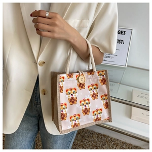 Close-up of cute cartoon tiger linen handbag with wooden button and rope handle detail