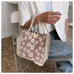 Detail of linen tote bag featuring white floral jacquard and woven rope handles