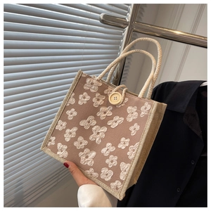 Détail d'un sac à main avec motifs floraux 3D et poignée en corde de coton tressé