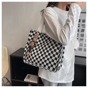 Close-up of checkerboard canvas tote bag with a cute matching rabbit doll pendant charm