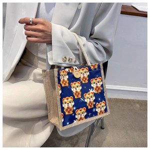 Close-up of linen tote bag with cartoon tiger pattern and round wooden button closure