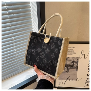 Vue détaillée du sac en lin avec applique florale, bouton en bois et anses en corde