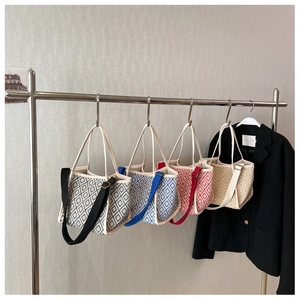 Detailed display of four geometric pattern canvas bucket bags in various colors on a rack
