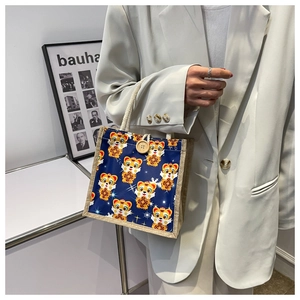Detail of cartoon tiger linen tote bag with wooden button closure and cotton rope handle