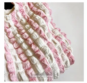 Detail shot of pink and white striped seersucker fabric with pleated 3D texture