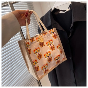 Detail of cute cartoon tiger linen handbag with wooden button closure and cotton rope handle