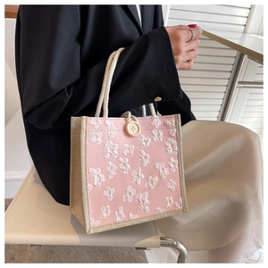 Detail of pink canvas tote bag with 3D floral embroidery and thick rope handles