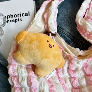 Close-up of a yellow star plush charm with a smiling face on a pink wavy pattern bag