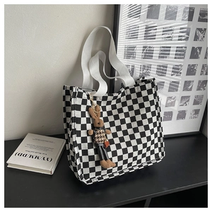 Close-up of checkerboard canvas tote bag with a cute brown bunny plush charm detail