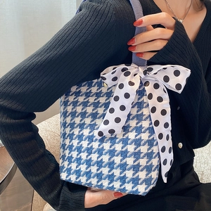Blue houndstooth woven handbag featuring a large polka dot bow for daily styling