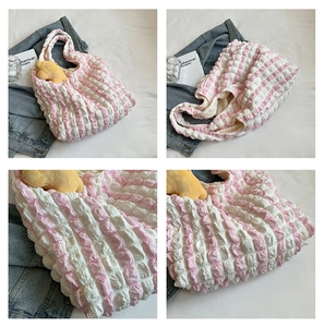 Close-up of pink white striped puffer tote bag fabric with cute bear charm detail