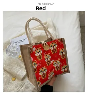 Detail of red burlap lunch bag with cartoon tiger patterns and wooden button closure