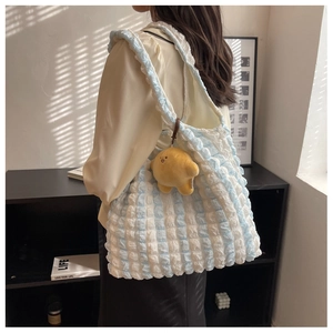 Detail of blue and white striped puffy tote bag with a cute yellow duck plush charm