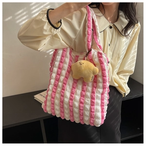 Detail of pink and white striped scrunchie tote bag with yellow star plush charm
