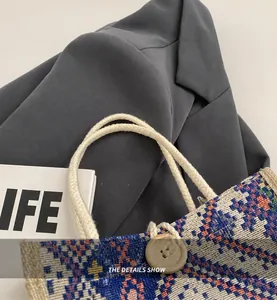 Detail der Ethno-Canvas-Tasche mit cremefarbenen Baumwollseilgriffen und Karo-Textur
