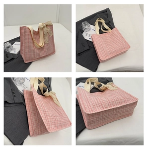 Detail view of pink and white checkered tweed tote bag with lace bow accessory
