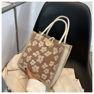 Detail of linen lunch bag with floral embroidery and natural hemp rope handles